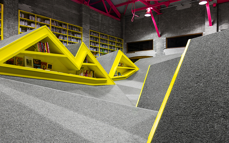 Illustration for article titled A Mountain Range of Shelves Turns This Kids' Library Into a Playground